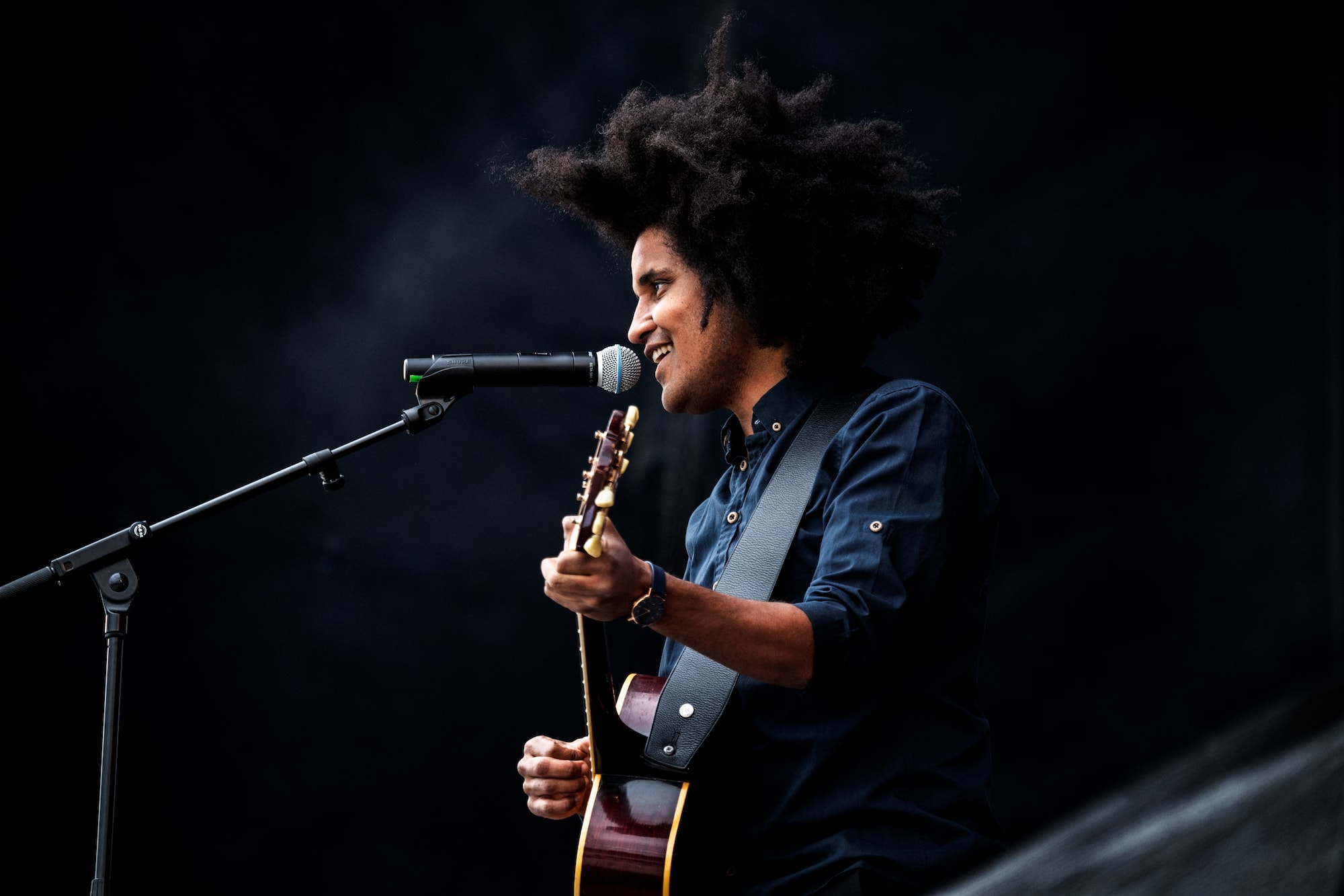 Thomas Buttenschøn på scenen med guitar og mikrofon.